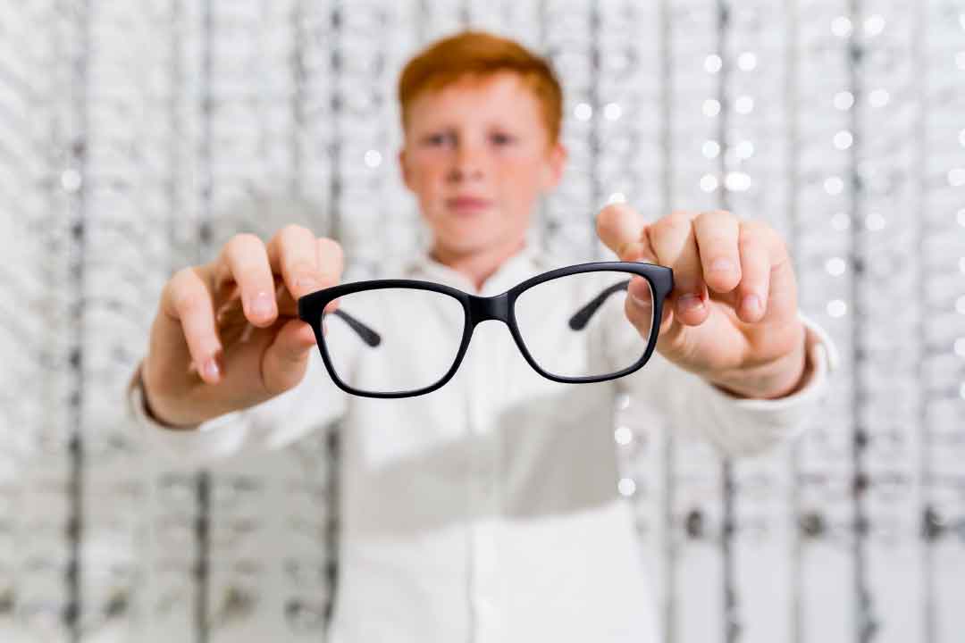 Child trying on glasses in an eye test for children
